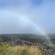 A rainbow over a lush and mountainous area